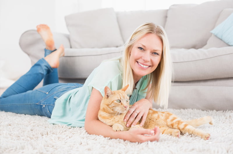 woman happy with her cat on clean fresh carpet